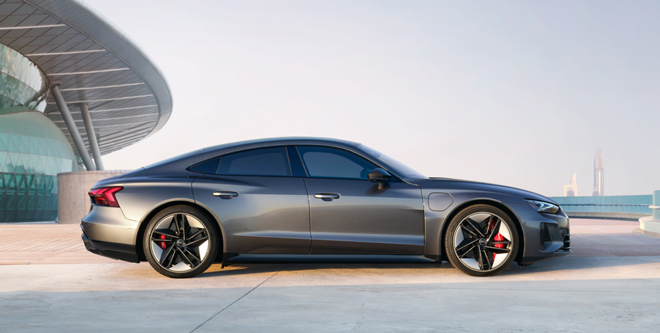 Seitenansicht eines Audi RS e-tron GT vor urbanem Geb&auml;ude