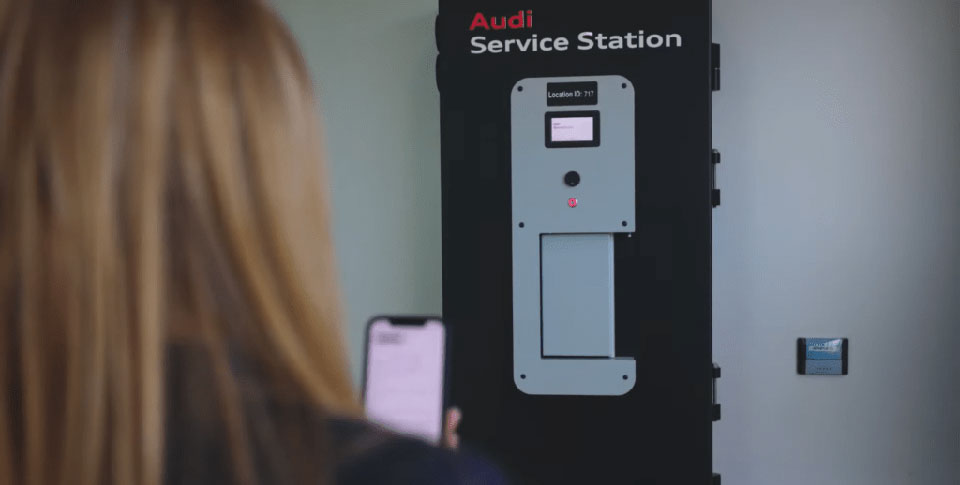 Hinterkopf von Frau mit Smartphone in der Hand vor Sharebox